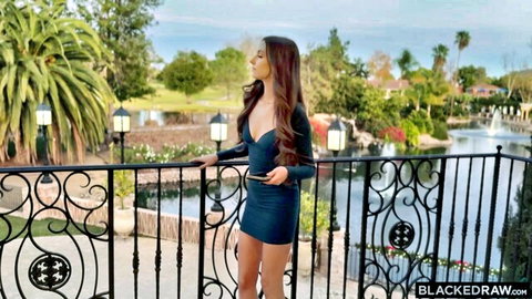 Tanned brunette babe in tight cleavage-revealing mini dress teases on scenic balcony
