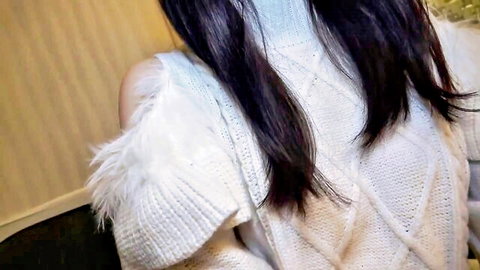 Sexy young brunette in off-shoulder fuzzy white sweater teasing back view