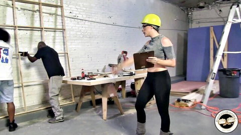 Chanel Preston in hard hat with two black men on construction set