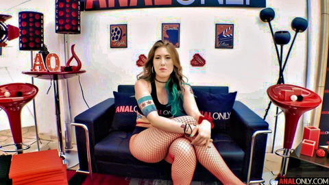 Electra Rayne in revealing top and fishnet stockings, seductive pose
