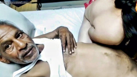 Busty young Indian woman presses huge tits on old Indian man's face in bed