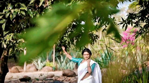 Resmi R Nair in white saree posing outdoors, seductive OnlyFans tease