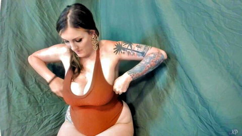 Kelly Payne pregnant in tight orange swimsuit showing tattoos and curves