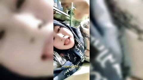 Playful Madura wife in hijab teasing with tongue out close-up