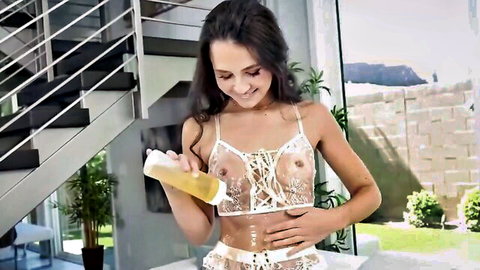 Liz Jordan in sheer white lingerie pouring lube on her perky tits, smiling seductively