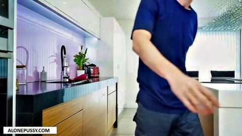 Handsome plumber in blue shirt teasing in modern kitchen