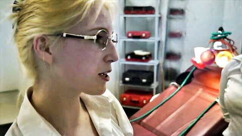Blonde woman with round glasses in white shirt, profile view in lab