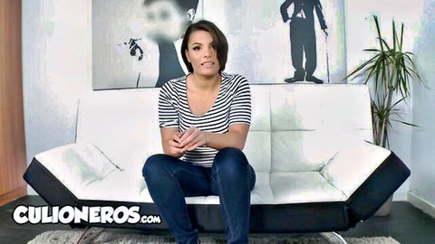 Amy Wild in Culioneros casting interview, smiling brunette Latina on couch