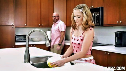 Blonde Madison Wilde in pink tank top washing dishes, stepdad watching in kitchen