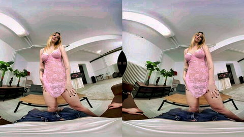 Curvy blonde woman in pink lace lingerie posing on low surface