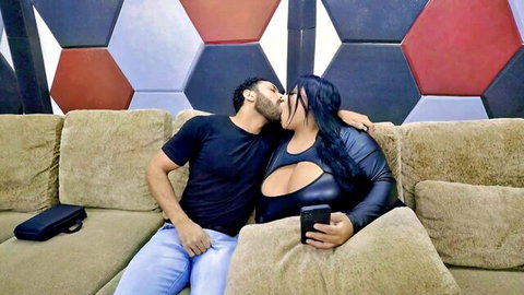 BBW with massive tits in revealing fishnet bodysuit passionately kissing muscular guy on couch