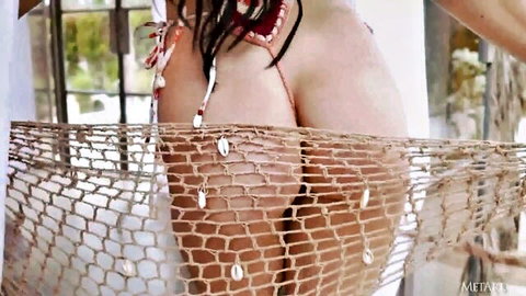 Skinny fair babe's bare ass cheeks framed by beaded net hammock outdoors