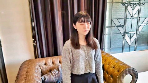 Baby-faced Japanese student relaxing in gray sweater and black skirt