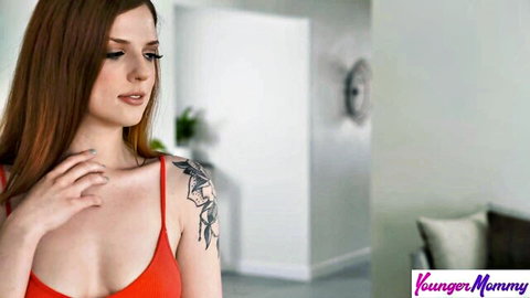 Scarlett Mae redhead in red top, seductive gaze, shoulder tattoo