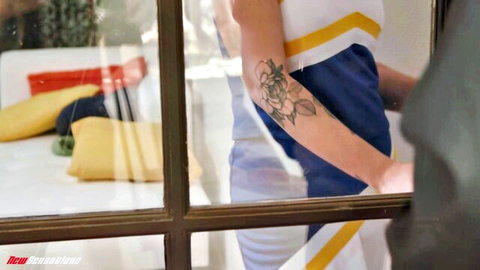 Sky Wonderland showing floral arm tattoo in fitted white tank top