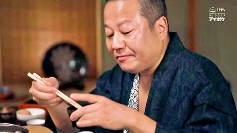 Mature Japanese boss in dark yukata eating with chopsticks at traditional table, JAV business trip scene
