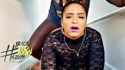 Ebony woman in sheer black lace top with O-face, man behind, BLK PORN MATTERS thumbnail