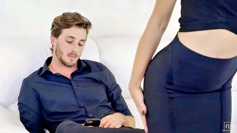 Skinny brunette in tight black dress gropes man's crotch on couch tease