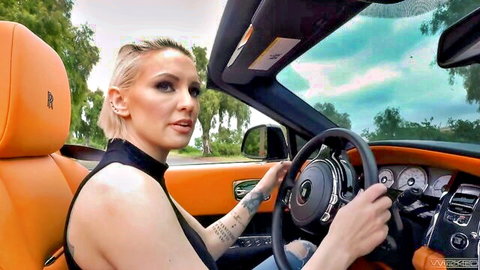 Blonde Haley driving orange Rolls Royce in sexy black top, POV style