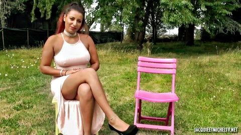 Seductive French woman in short pink dress posing on grass for threesome tease