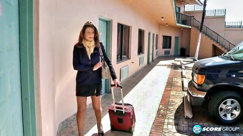 Deauxma in sexy blazer and mini skirt pulling suitcase at motel