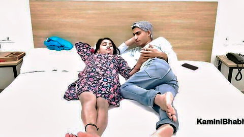 Sexy Indian bhabhi Kaminibhabhi lounging on bed in short floral dress with lover caressing her thigh