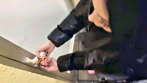 Woman in black leather jacket opens door, teasing entry to Berlin sex adventure