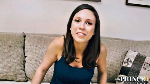 Smiling brunette babe in tank top showing cleavage on couch