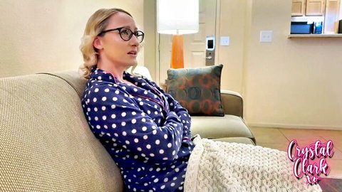 Blonde MILF Crystal Clark in glasses lounges on couch in polka dot pajamas