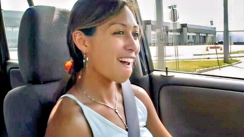 Venus Lopez smiling in car, white tank top, Latina beauty teasing
