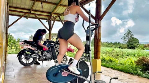 Angel-Victoria in tight sports bra and shorts on exercise bike, outdoor tease