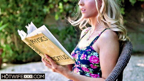 Seductive blonde in floral dress reading physics book teasingly