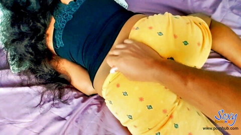 Cool Brownis in yellow pants lies on bed as hand caresses her midriff