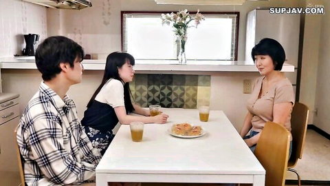 Japanese MILF with big tits sits with young couple at table in JAV tease scene