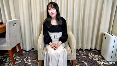 Japanese woman with braces smiling in black blouse and cream skirt
