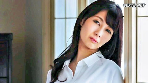 Japanese MILF housewife with big tits posing seductively in white blouse by window
