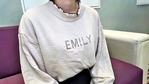 Cute girl in sparkly Emily sweatshirt sitting teasingly on purple couch