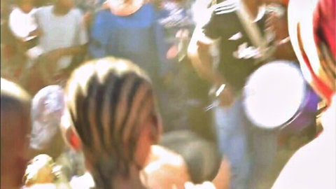Blurry street crowd at bango baikoko flash event with drummers and braided hair woman