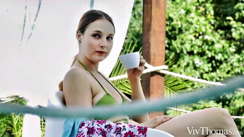 Ophelia Dust in green bikini relaxing outdoors with coffee cup