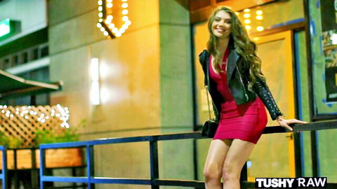 Tiffany Tatum posing seductively in red dress and leather jacket outdoors