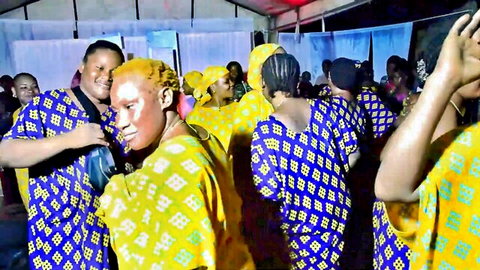 Tanzanian women dancing in colorful traditional dresses and headwraps