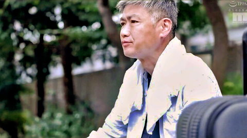 Older Asian man with towel around neck gazes outdoors in Japanese taboo episode