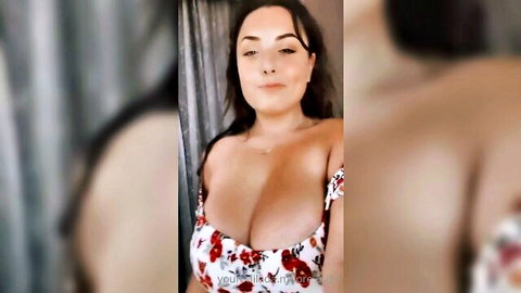 Milada Moore in low-cut floral dress showing deep cleavage, seductive smile