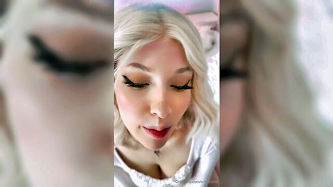 Milkimind blonde with heavy makeup and deep cleavage in white top, seductive lips
