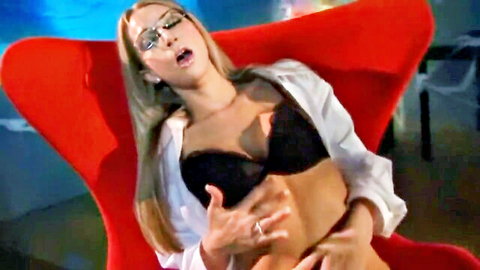 Blonde woman in glasses and black lingerie seductively poses with open white shirt