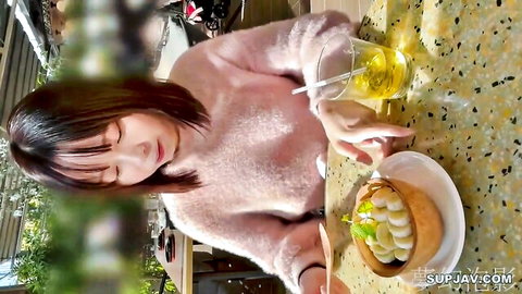 Cute Asian college girl like Nishino Ni in pink sweater eating dessert