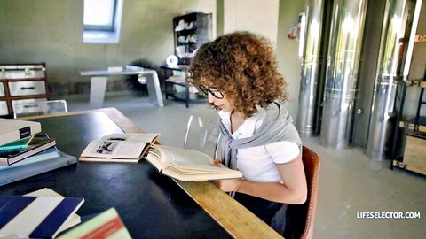 Geisha Kyd as curly haired babe with glasses in schoolgirl outfit reading