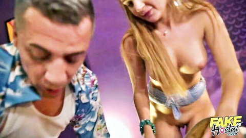 Blonde babe with fake tits stands naked as man licks her shaved pussy in hotel room