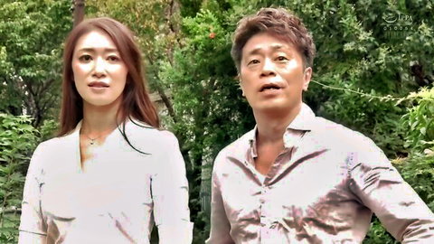 Attractive long-haired Japanese woman and mature man smiling together in lush green garden