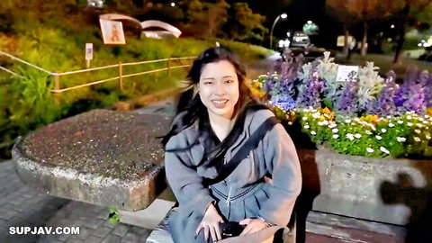 Smiling Asian amateur in gray coat on night park bench, first-time JAV reveal